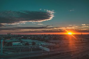 Stunning sunset over Ghan, NT, Australia with a city skyline and vibrant sky.